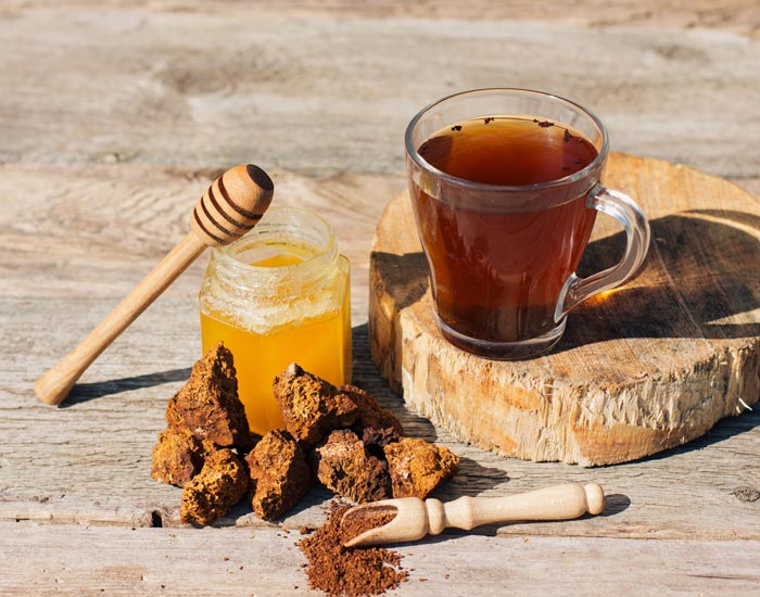 Tea, honey, and chaga mushroom  on a wooden surface