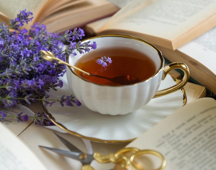 Teacup with lavender and a book on a wooden surface