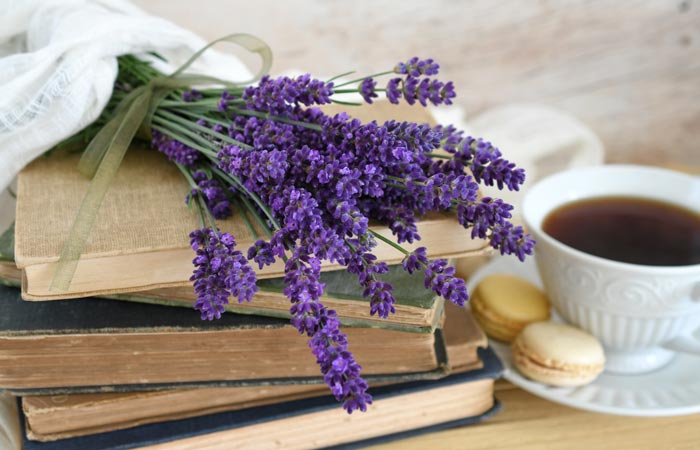 Bouquet of lavender on top of books with a cup of coffee and cookies in the background